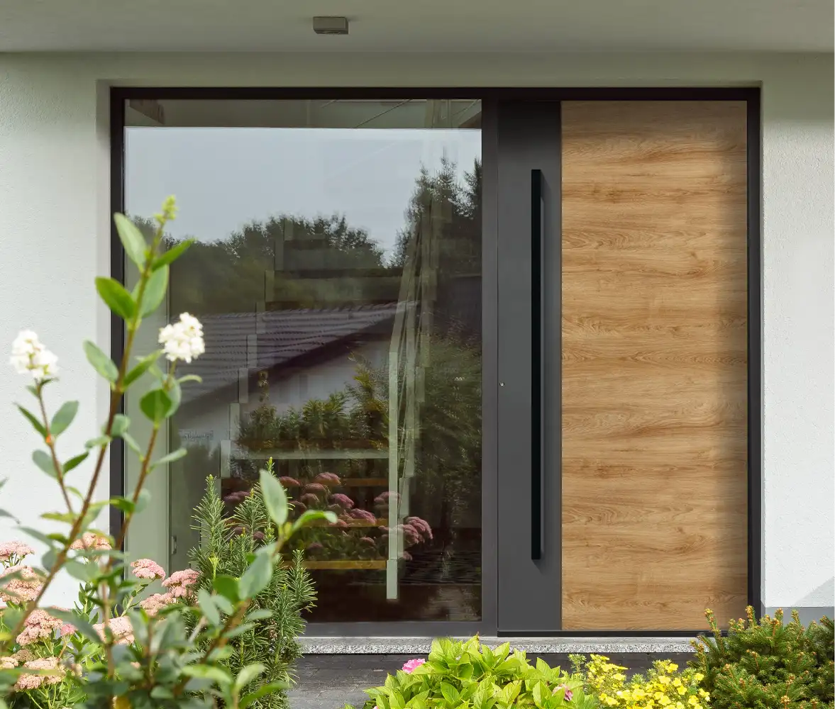 Moderne Haustür in Anthrazit und heller Holzoptik mit langem schwarzem Griff und großem seitlichem Glaselement