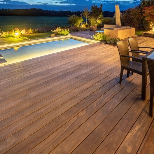 Kebony - dunkle Holzterrasse mit Pool am Abend