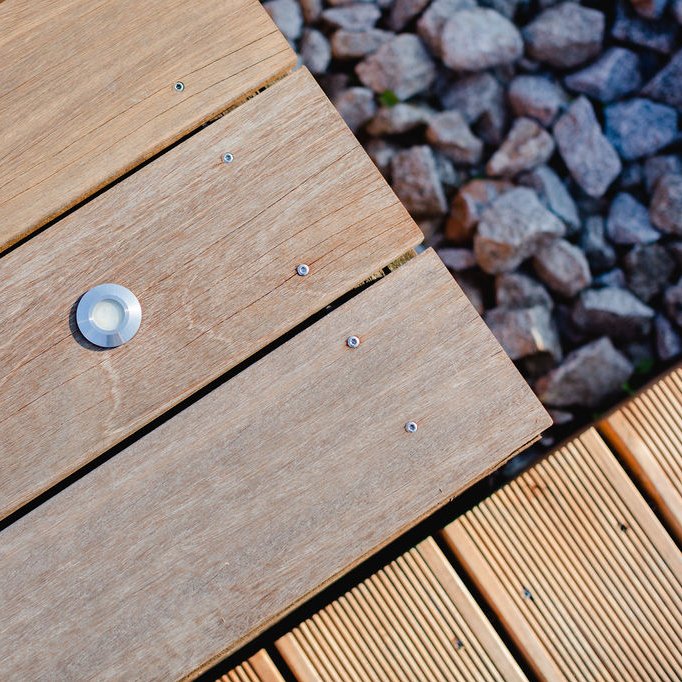 Nahaufnahme verlegter Holzterrassenvarianten, glatt und geriffelt